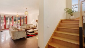 Ein modernes Wohnzimmer mit Sofa, Couchtisch und einer Treppe zu einer oberen Etage.