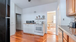 A kitchen with white cabinets, a stove, a microwave, and a dishwasher. - Spacious 3BDR near Harvard/5-Min Walk to Train - Davis Sq / Free Parking! (Somerville)