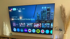 A flat-screen TV mounted on a wooden stand with a cityscape background. - PROMO August 20% off! 5 bed/3bath/private pool-Disney/Universal (Clermont)