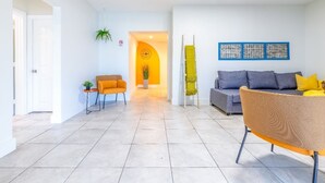 A modern living room with a sofa, a chair, and a small table with a plant.