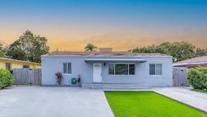 A single-story house with a front yard and a clear sky.