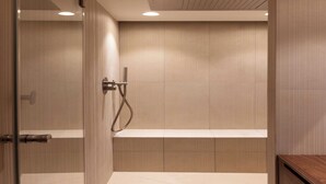 Une salle de bain moderne avec une douche à l’italienne en verre, une baignoire et un meuble-lavabo en bois.