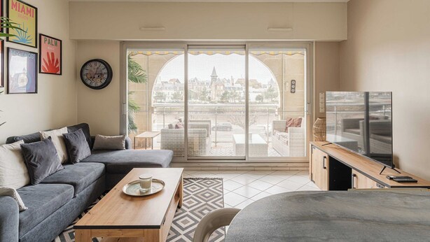 A modern living room with a grey sofa, a wooden coffee table, and a TV on a wooden stand. - Modern Apartment with Terrace Trouville (Trouville-sur-Mer)
