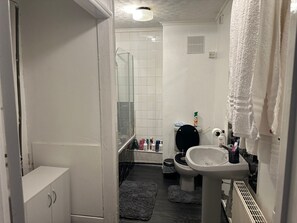A bathroom with a toilet, sink, and shower area. - Seaside Stay Sleeps 6 With Pets (Great Yarmouth)