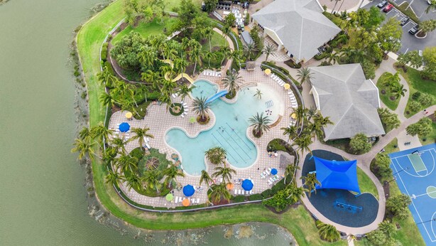 An aerial view of a resort with a central pool, surrounded by palm trees and lounge areas. - Sandy Bottoms - Resort Style Community Ammenities, Sandy Bottoms! (Cape Coral)