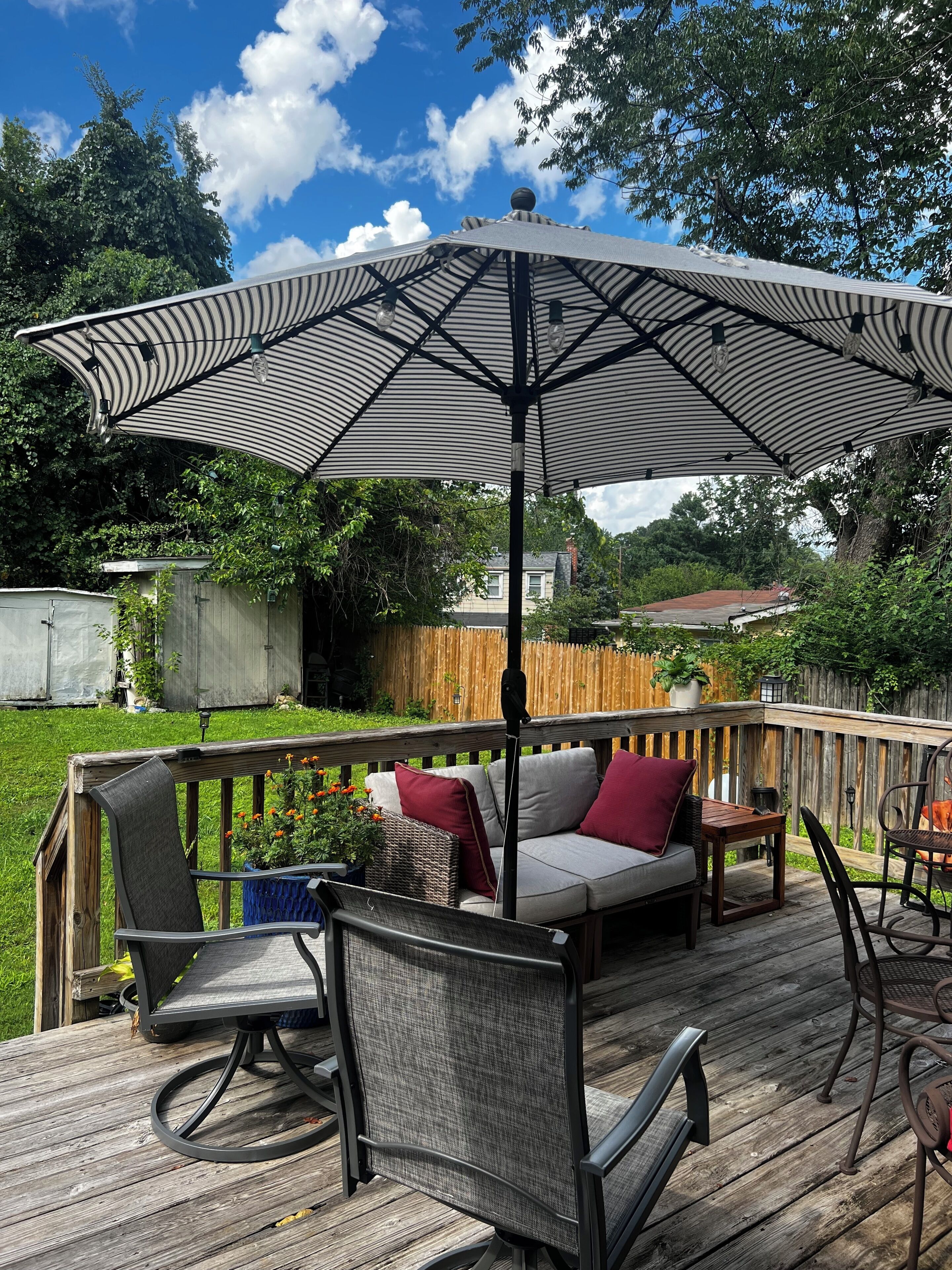 An outdoor deck with a covered seating area, a table, and chairs.