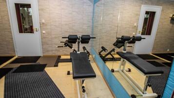 A gym with exercise equipment, a mirror, and a door.