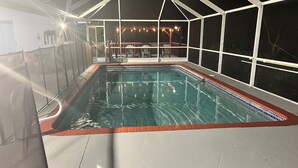 Una piscina coperta con bordo piastrellato, immersa in un’area riparata con struttura a tetto.