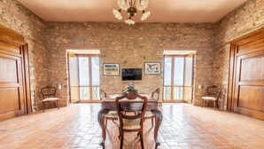 A dining area with a stone wall, wooden doors, and a tiled floor.