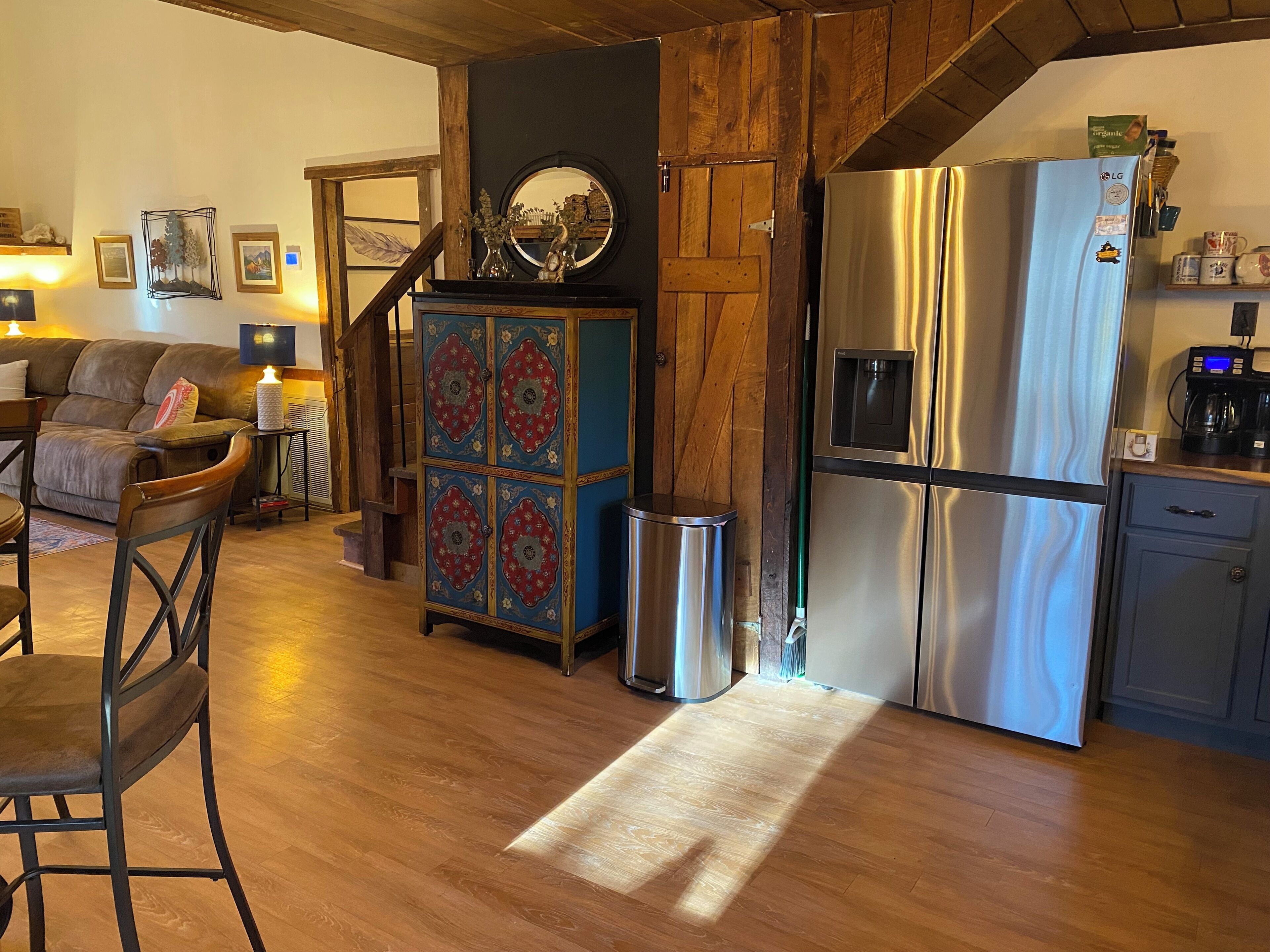 A modern kitchen with a stainless steel refrigerator, wooden cabinets, and a built-in oven.