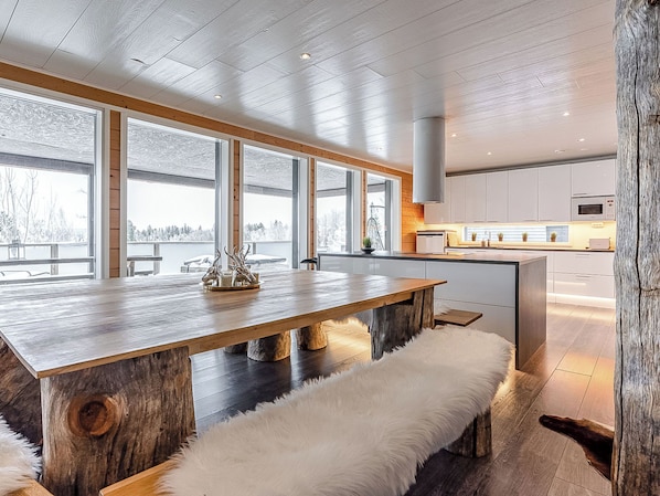 Una cocina moderna con una isla de madera, ventanas amplias y vistas al exterior.