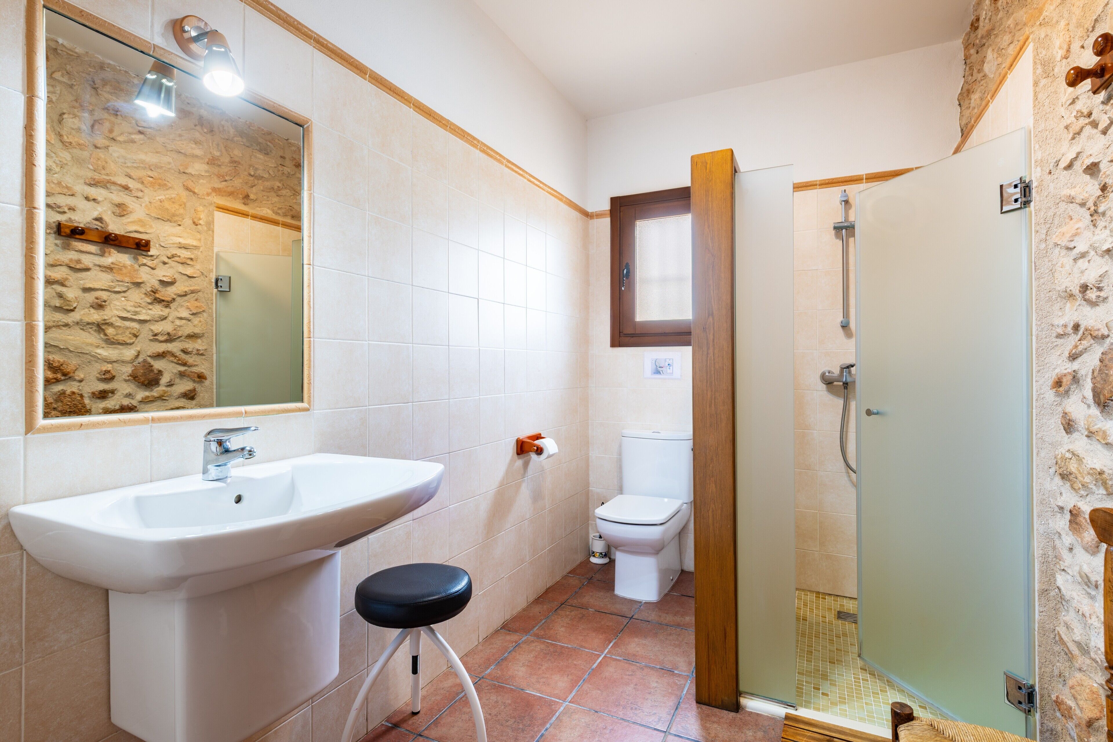 Une salle de bain avec un lavabo, des toilettes et une douche.