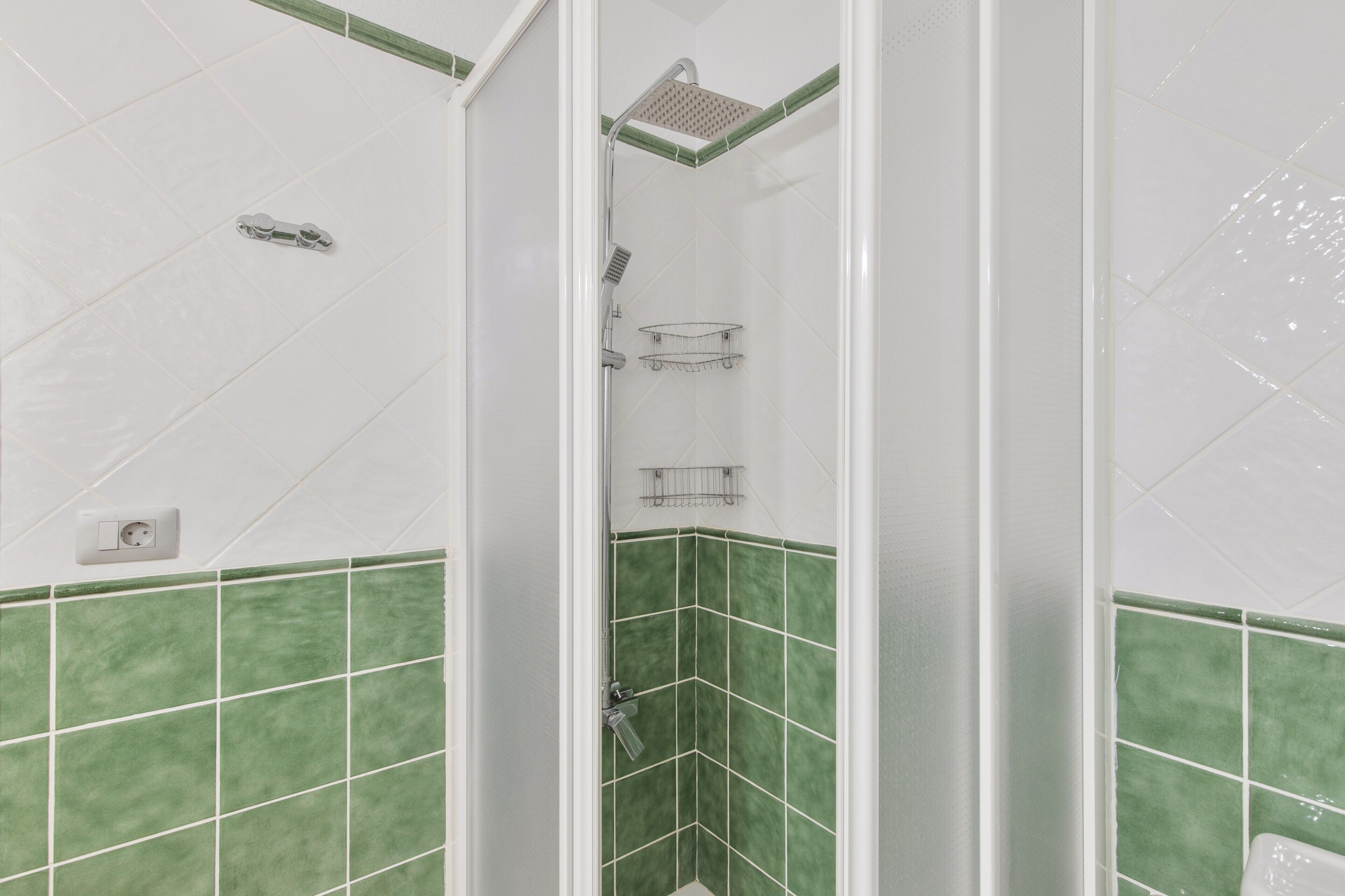 Ein Badezimmer mit Dusche, Handtrockner und Handtuchhalter.