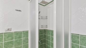Ein Badezimmer mit Dusche, Handtrockner und Handtuchhalter.