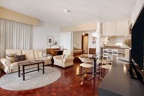 Een moderne woonkamer met een bank, salontafel en een eethoek met stoelen en een tafel.