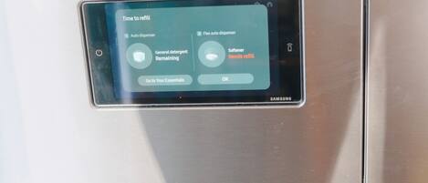 Ein Samsung-Gerät, dessen Bildschirm eine Erinnerung zum Nachfüllen für automatische und flexible Automaten anzeigt, einschließlich Waschmittel und Weichspüler.