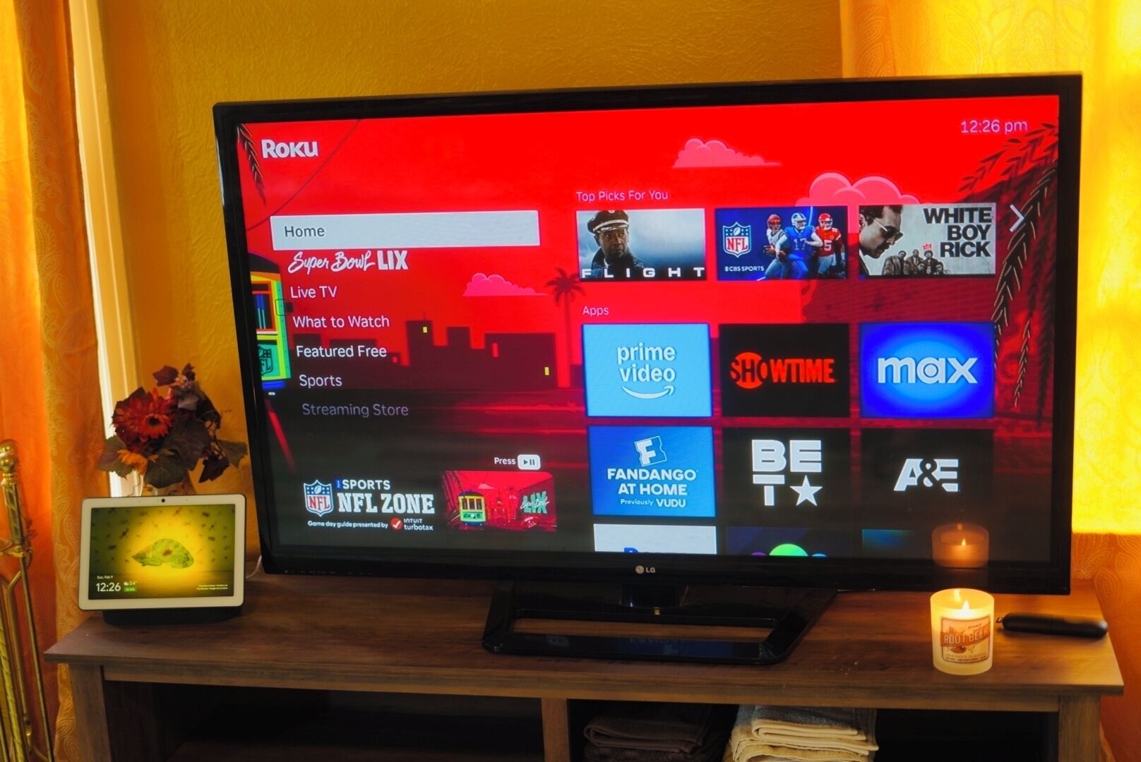 Ein Roku-Fernseher auf einem Holzständer, der die Roku-Oberfläche mit verschiedenen Streaming-Angeboten zeigt.