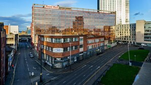A modern building with a glass facade, a sign for 'Royal Mail', and a street view with cars and a pedestrian crossing. - City Centre | Cathedral Quarter | Walk Everywhere - Pass the Keys (Belfast)