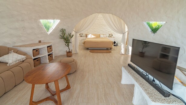 A cozy, well-lit room with a bed, a TV, a sofa, and a small table. - The Dome Villa Canggu (Canggu)