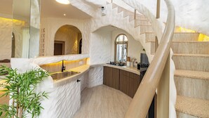A modern kitchen with a curved staircase, marble countertops, and a built-in sink. - The Dome Villa Canggu (Canggu)