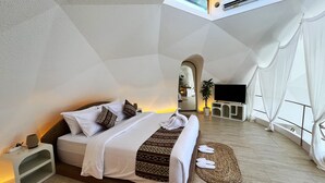 A modern bedroom with a bed, a TV, and a potted plant. - The Dome Villa Canggu (Canggu)