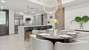 A modern kitchen with a central island, stainless steel appliances, and pendant lighting. - Renovated 2-bedroom condo with WiFi, AC inside Bahía Beach Resort (Río Grande)