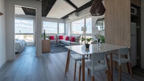 A modern living room with a dining area, large windows, and a city view. - MOT Azopardo 700 (Buenos Aires)