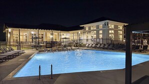 A swimming pool with lounge chairs and a building in the background. - Modern Comfort Near Mooresville's Attractions (Mooresville)