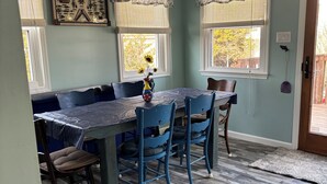 A dining area with a table and chairs, a decorative vase, and a window with curtains. - Beautiful 3 bedroom house in Villas NJ- dishwasher, washer/dryer, and ac. (Lower Township)