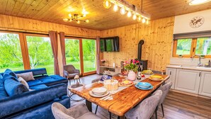 Un intérieur chaleureux en bois, avec un canapé, une table à manger, des chaises et un coin cuisine.
