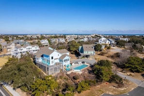 A residential area with houses, a swimming pool, and a clear view of the ocean.