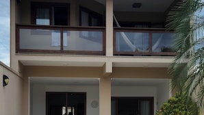 Un bâtiment à deux étages doté d’un balcon, d’une porte et d’une petite table.