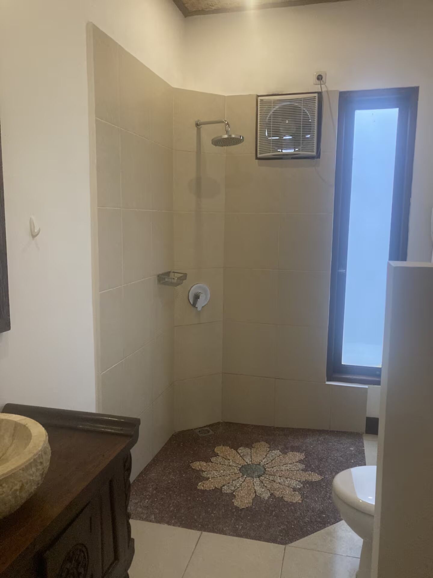 A bathroom with a shower, a toilet, and a sink.