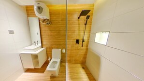 Een moderne badkamer met toilet, wastafel en douche.