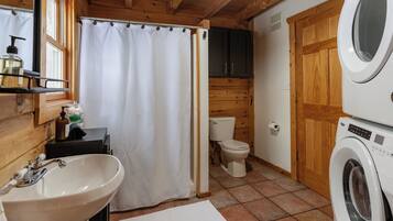 A bathroom with a sink, toilet, and washing machine.
