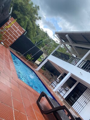 Relax by the pool surrounded by lush greenery and take in the views from the adjacent building's balconies.