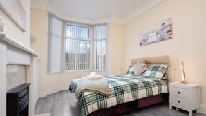 Ein Schlafzimmer mit Bett, Nachttisch und einem Bild an der Wand.