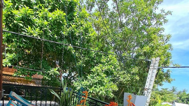 A wooden deck with a table, two water bottles, and a striped hammock. - Cong Man Homestay - Cham Island (Da Nang)