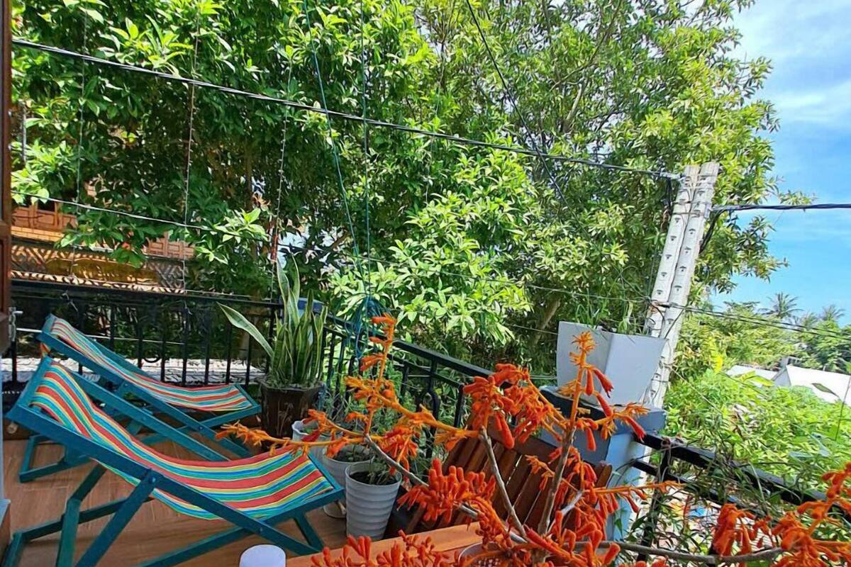 A wooden deck with a table, two water bottles, and a striped hammock.