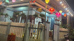 A building with a multi-level structure, decorated with colorful lights and hanging lanterns. - Cong Man Homestay - Cham Island (Da Nang)