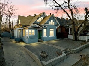 A two-story house with a gabled roof, a front porch, and a driveway leading to the entrance. - Beehive Bungalow | Central Location (Salt Lake City)