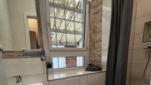 Un baño moderno con lavamanos, inodoro y ducha.