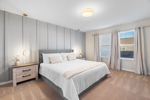 A bedroom with a bed, bedside tables, a nightstand, a wall-mounted light fixture, and a window with curtains. - Chic Home, Game Room, Themed Beds (Clermont)