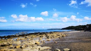 A rocky beach with clear skies and calm waters. - Thin End (Seaview)