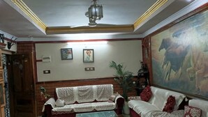 A living room with a sofa, a bench, a painting, and a ceiling fan.