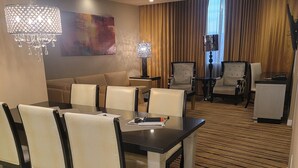 A hotel room with a dining area, a sofa, a chandelier, and a large window with curtains. - 2-bedroom villa hotel in phenomenal Las Vegas with WiFi, AC, fitness room (Las Vegas)