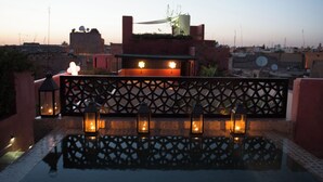 A rooftop terrace with a decorative fence, lanterns, and a small pool. - Ptit Habibi (Marrakech)