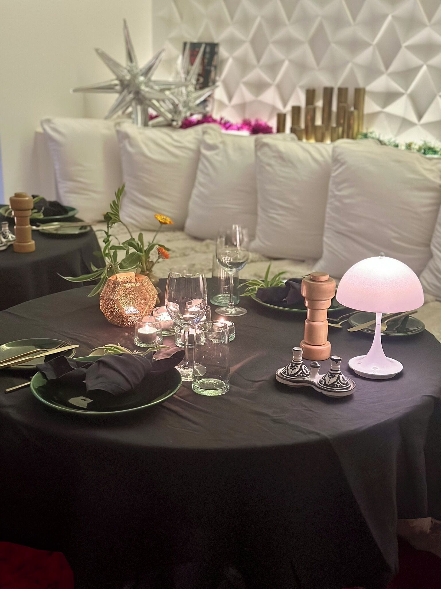 A dining table set with plates, cutlery, glasses, and a decorative centerpiece.