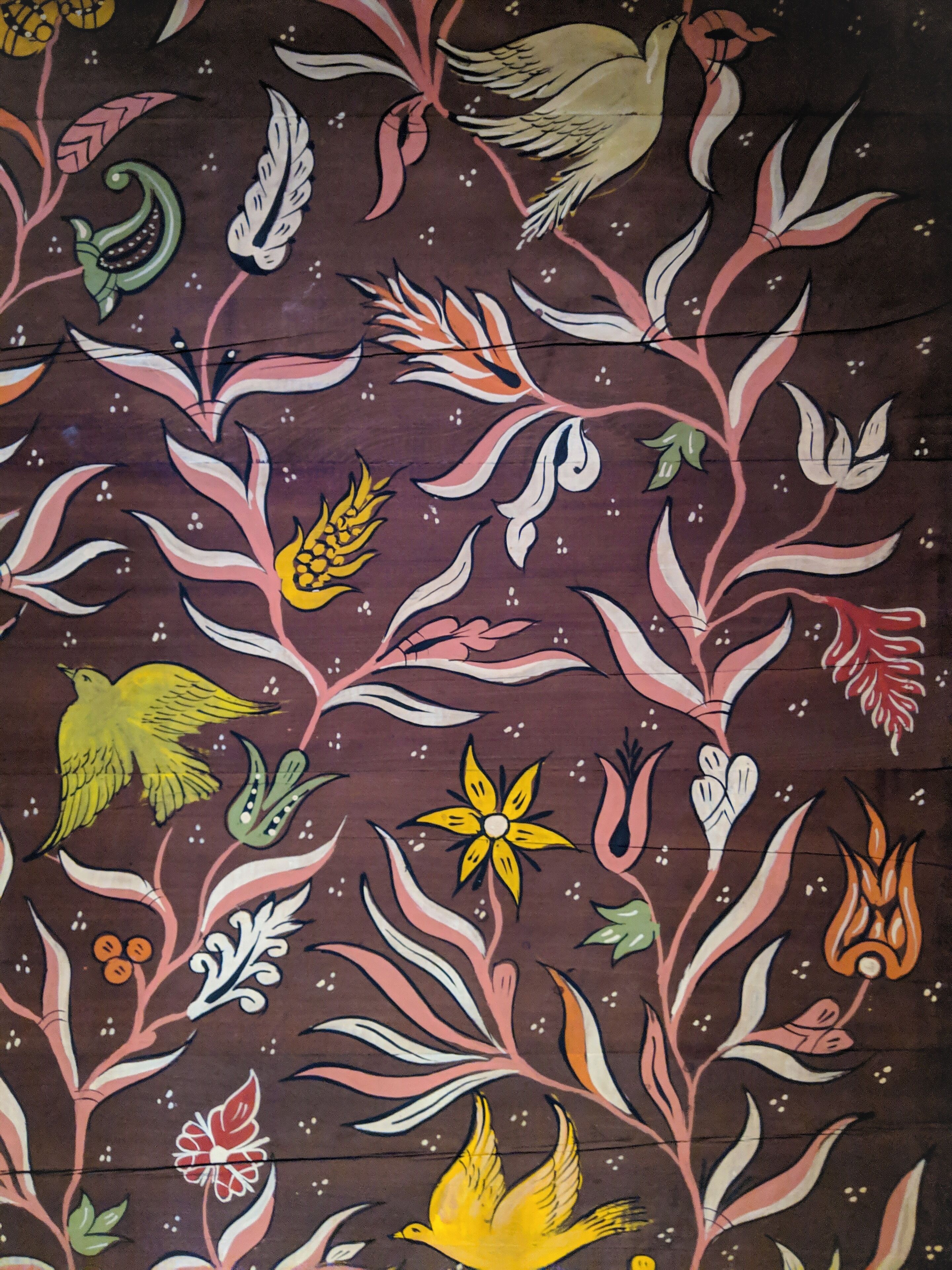 A wall with a floral and bird pattern.