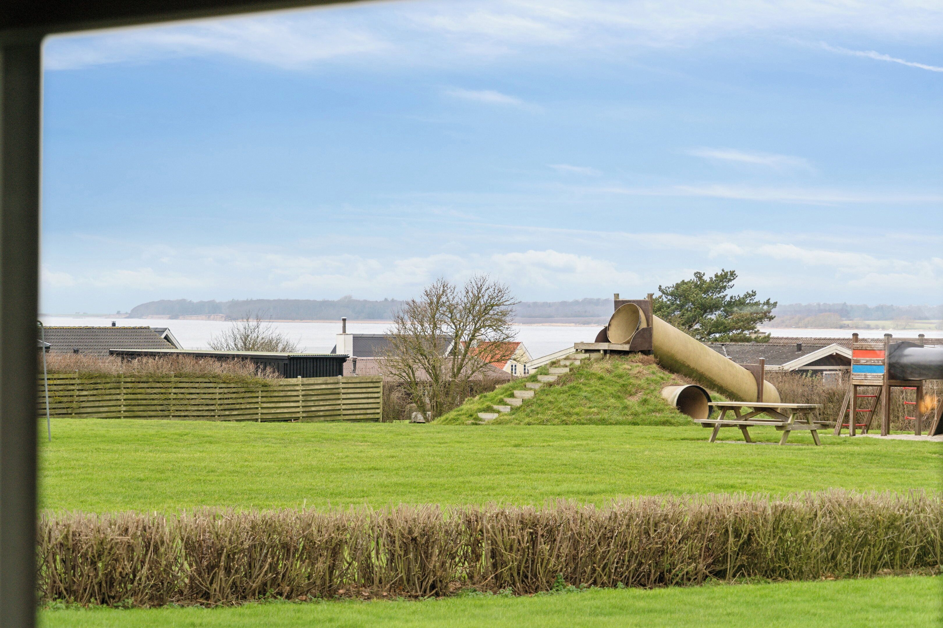 A grassy field with a picnic table and a large cylindrical structure.